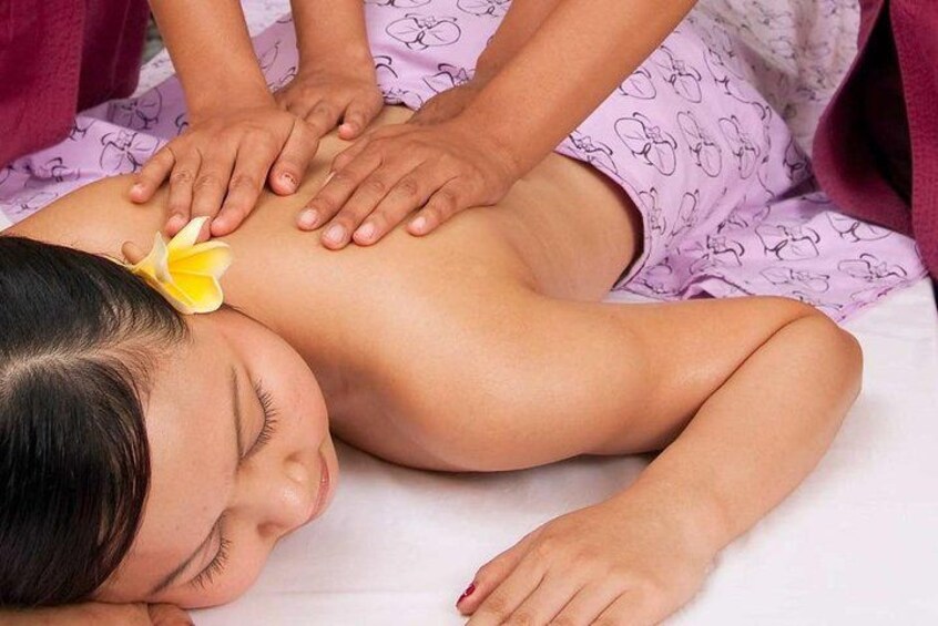 A person receiving a back massage with hands on their back. 2