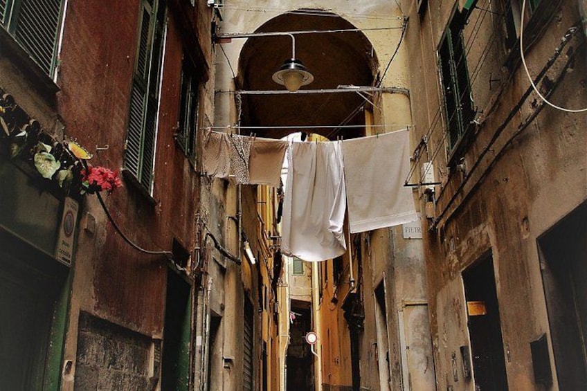 A narrow alley with hanging laundry and a vintage street lamp. 4