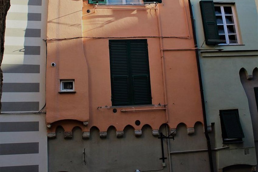 A building with a window, a small square window, and a door. 4