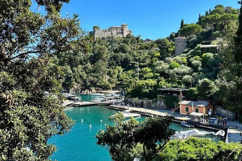 A coastal town with a marina, boats, and a castle on a hill. 3