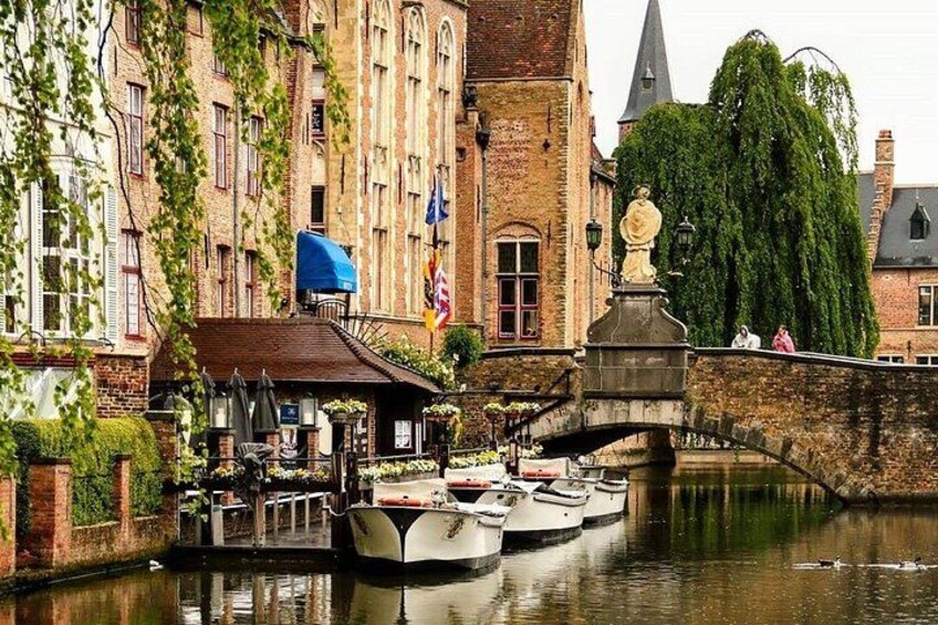 Ein Kanal mit Booten, einer Brücke und mit Efeu bewachsenen Gebäuden. 1