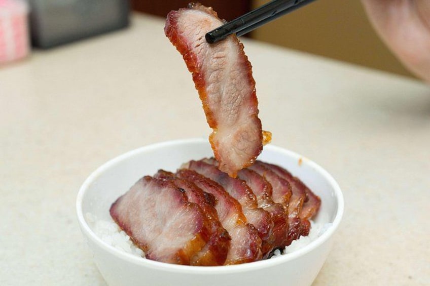 Un tazón de comida con rebanadas de carne sostenidas por palillos. 4