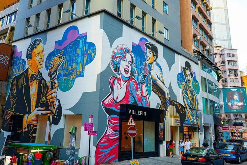 Un edificio con un mural grande, un letrero que dice 'VILLEPIN' y una señal de 'No Estacionar'. 2
