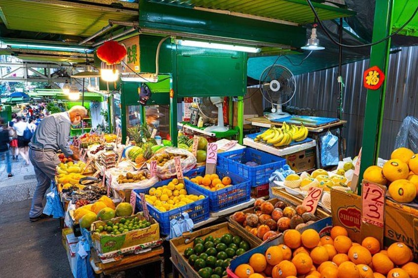 Un mercado techado lleno de actividad, con una gran variedad de frutas y verduras a la vista. 3