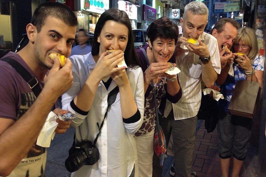 Un grupo de personas comiendo comida callejera en un entorno urbano. 5