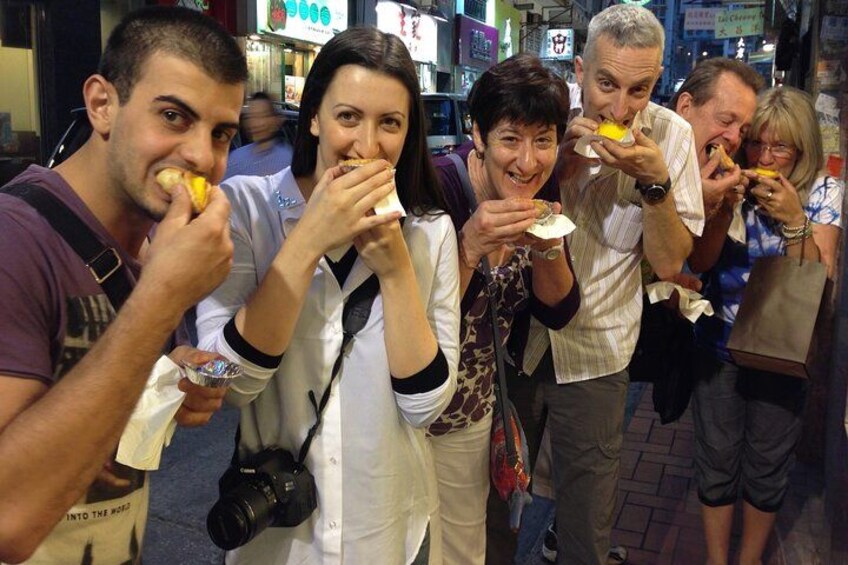 Un grupo de personas comiendo en un puesto de comida callejera. 2