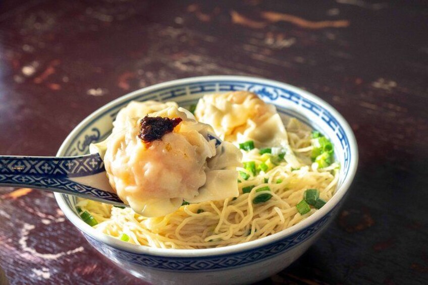 Un tazón de fideos con albóndigas y cebolletas. 3