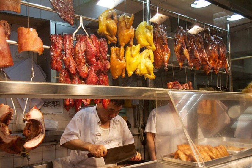 Un puesto de comida con diferentes carnes colgadas y exhibidas. 1