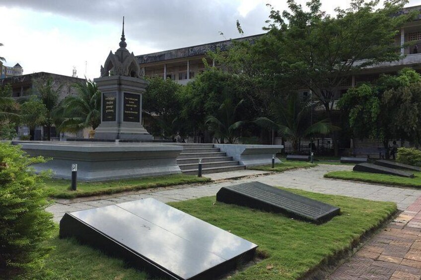 En park med ett monument, bänkar och en fontän. 2