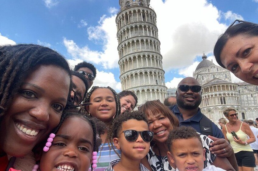 A group of people in front of the Leaning Tower of Pisa. 2