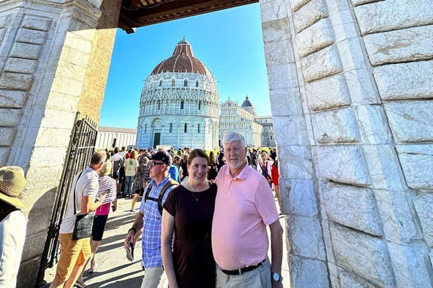 A group of people standing in front of the Pisa Cathedral with the Leaning Tower in the background. 3