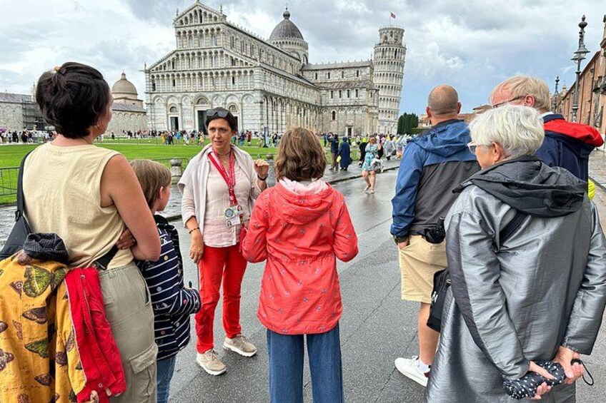 A group of people standing in a square with a historic building in the background. 4