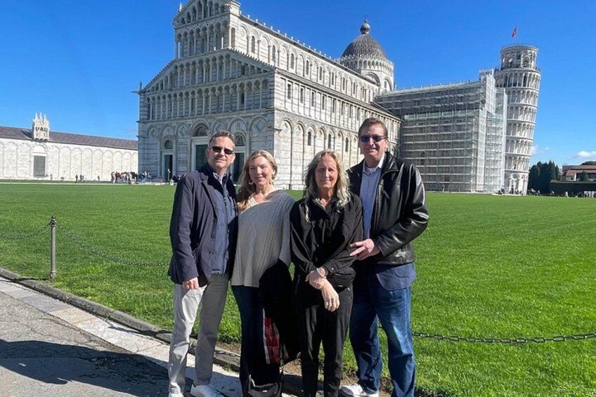 A group of people standing in front of the Leaning Tower of Pisa. 1