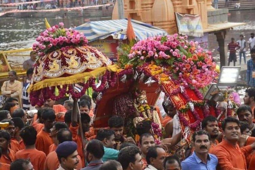 A crowd of people, a decorated vehicle, and a river. 5