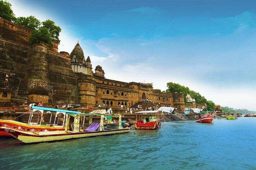 A river with boats, a stone fort, and a clear sky. 2