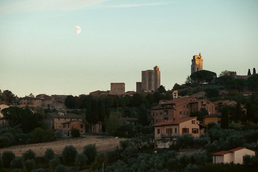 A town with historic buildings, a prominent tower, and a crescent moon in the sky. 3