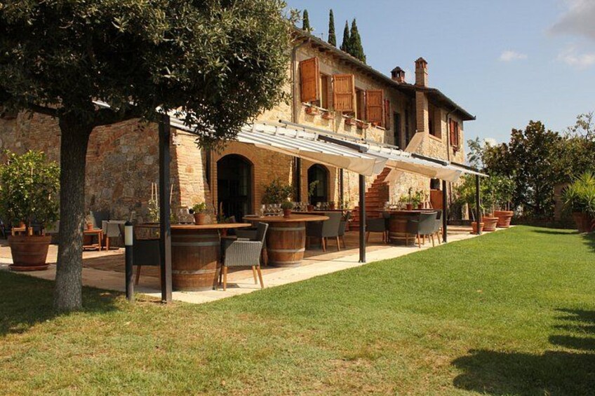 A stone building with a patio, outdoor seating, and a well-maintained lawn. 2