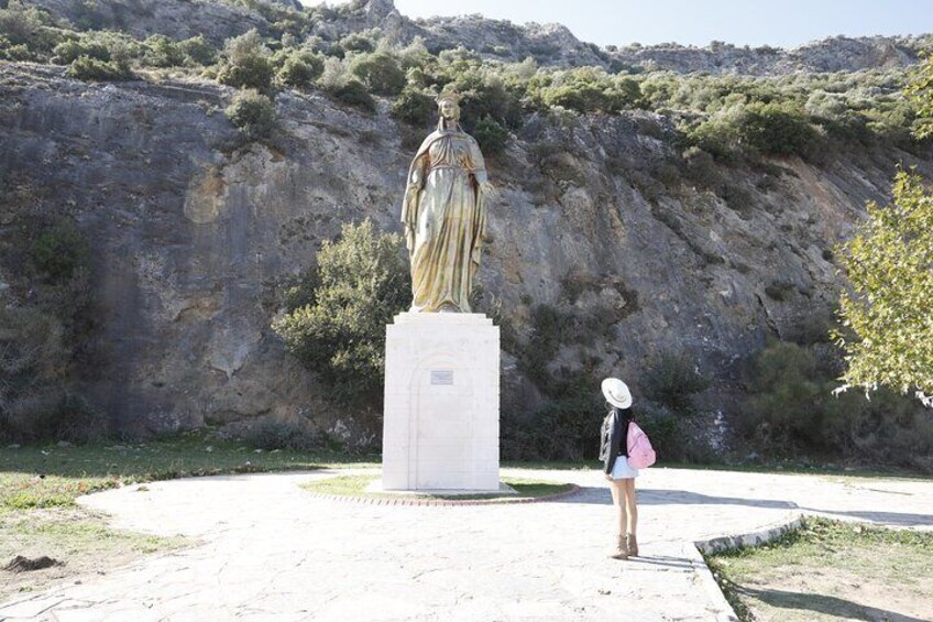 A statue in a park with a rocky hillside in the background. 3