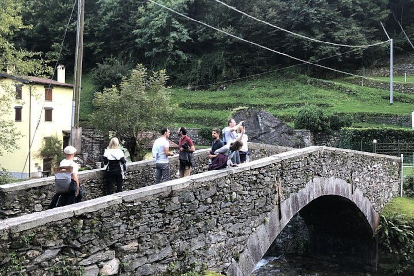 Un pont de pierre enjambe un ruisseau, et des personnes le traversent à pied. 3