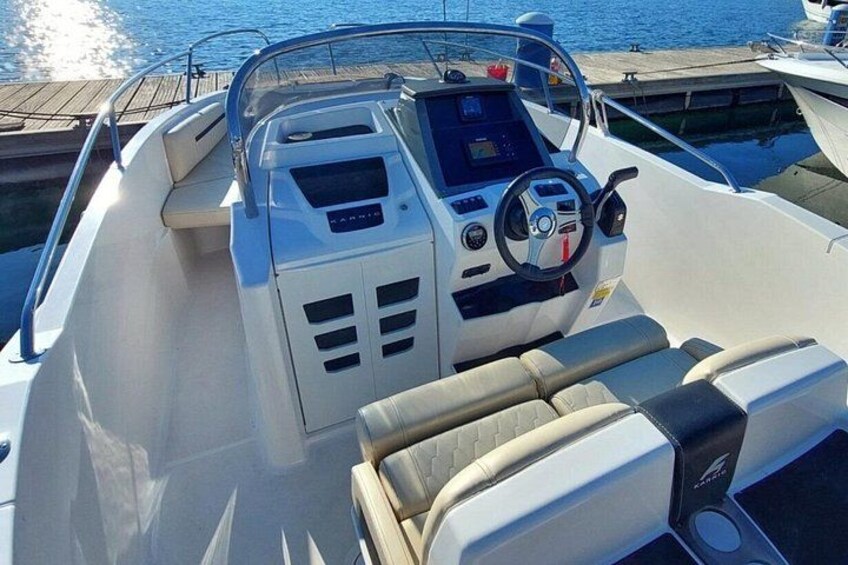 L'intérieur d'un bateau, avec un volant, un panneau de commande et des sièges rembourrés. 2