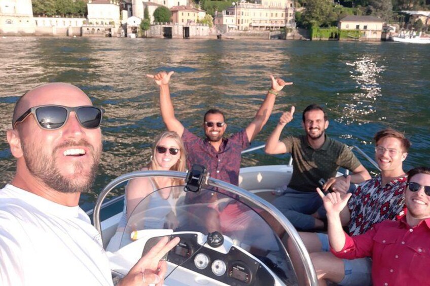 Un grupo de personas en un bote, con un río y edificios al fondo. 1