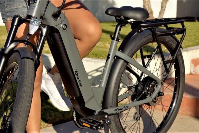 Primer plano de una bicicleta con suspensión delantera, un portaequipajes trasero y un sistema de transmisión por cadena. 5