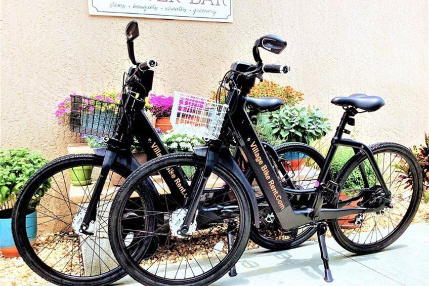 Dos bicicletas estacionadas junto a una pared con un letrero encima. 3