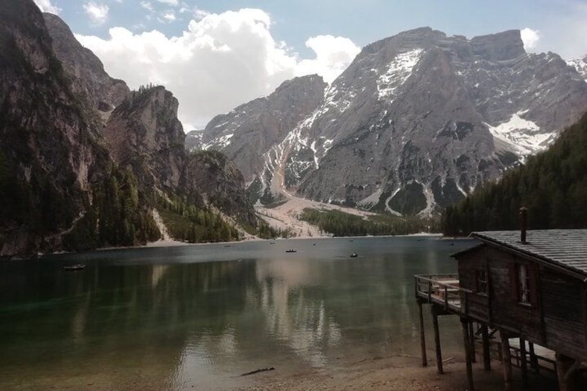 A mountain lake with a wooden dock and a cabin. 2