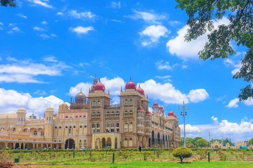 A large, ornate building with multiple domes and arches, surrounded by a green landscape. 3