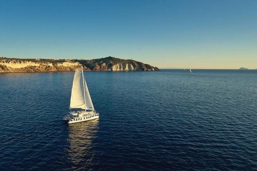 A sailboat on calm waters with a coastline in the background. 3