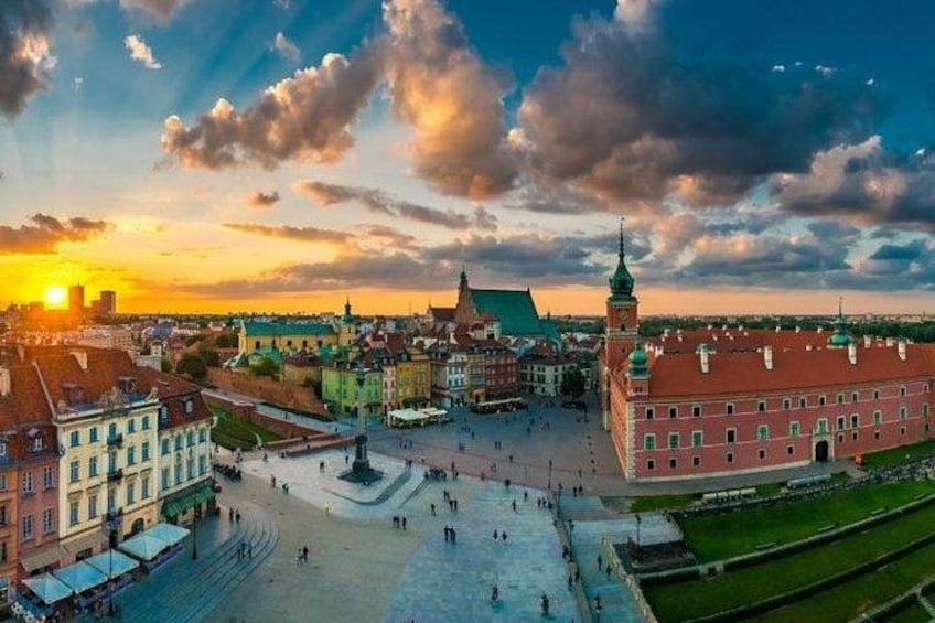 A city square with historic buildings, a prominent tower, and a clear sky. 4