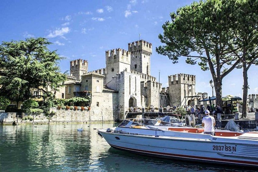 Un castillo junto a un cuerpo de agua tranquilo con un bote amarrado en la orilla. 1