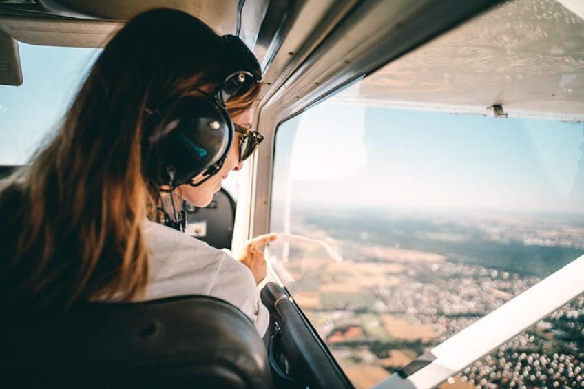 A person in a cockpit with a view of a landscape through the window. 3
