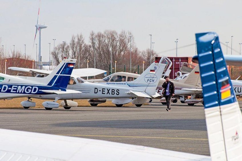 Small aircraft parked on a runway with visible registration numbers. 1