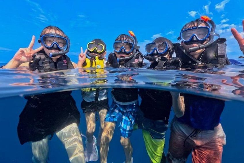 A group of people snorkeling underwater, wearing diving gear and masks. 2