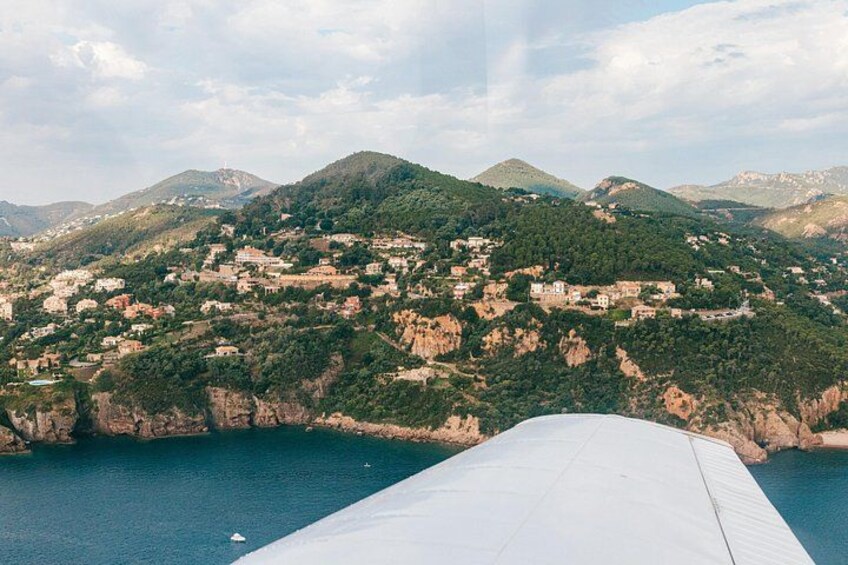 Paesaggio costiero con montagne sullo sfondo, una distesa d'acqua e una struttura bianca in primo piano. 1