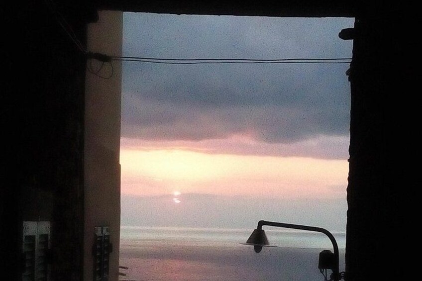 Ein Sonnenuntergang über dem Wasser, eine Lampe und ein Vorhang. 3