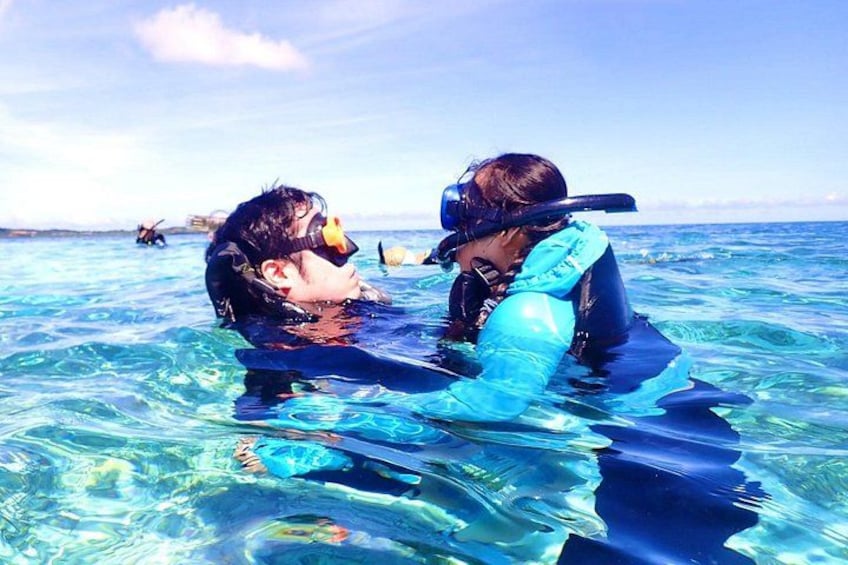 Two people snorkeling in clear blue water. 4