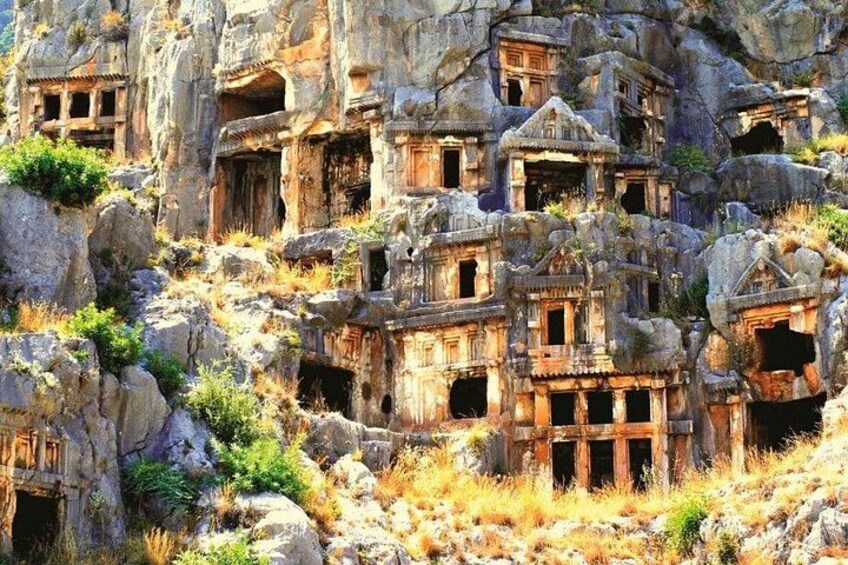 Alte, in Fels gehauene Architektur mit mehreren Strukturen, die in die Klippe gemeißelt sind. 1