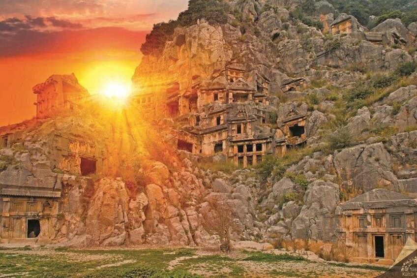 Alte, in Fels gehauene Architektur mit untergehendem Sonnenuntergang im Hintergrund. 5