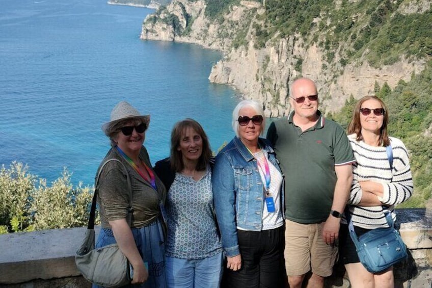 A group of people standing on a cliff overlooking a coastal landscape with cliffs and the sea. 2