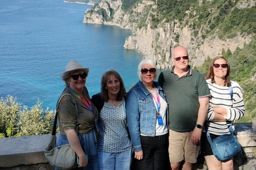 A group of people standing on a cliff overlooking a coastal landscape with cliffs and the sea. 2
