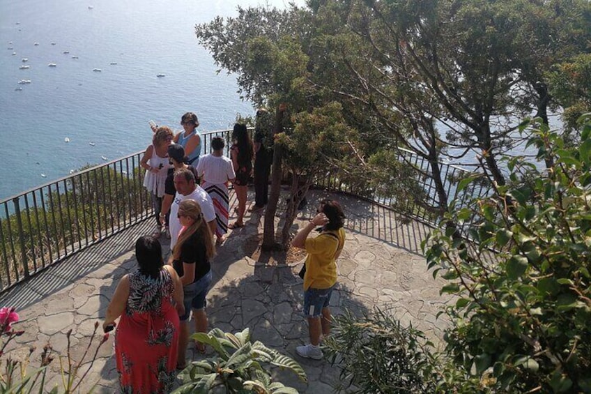 A group of people on a stone staircase overlooking a body of water with boats. 1