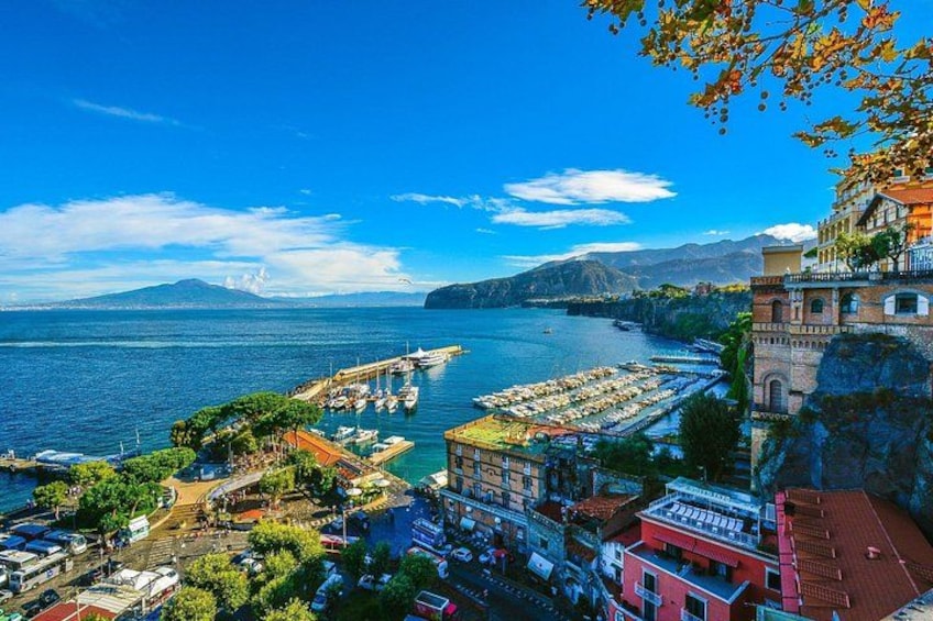 A coastal town with a marina, buildings, and mountains in the background. 5