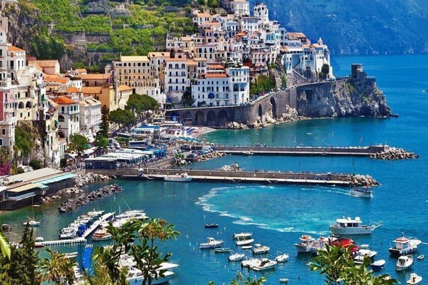 A coastal town with buildings, a harbor, and boats. 4