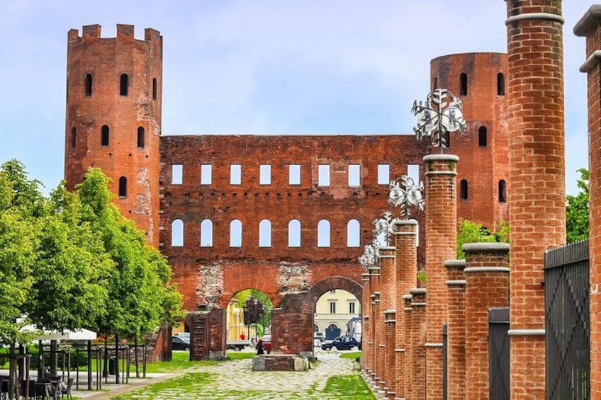A historic brick castle with towers, arched windows, and a central archway. 2
