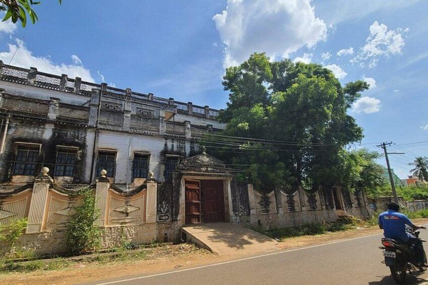 A historic building with ornate architecture, a paved road, and a motorcyclist. 5