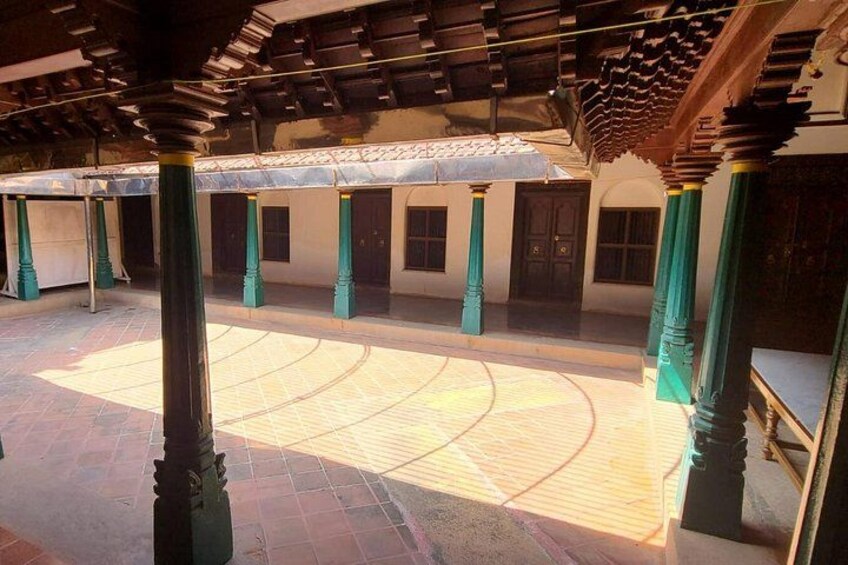 An interior courtyard with columns, a tiled floor, and a ceiling with wooden beams. 2
