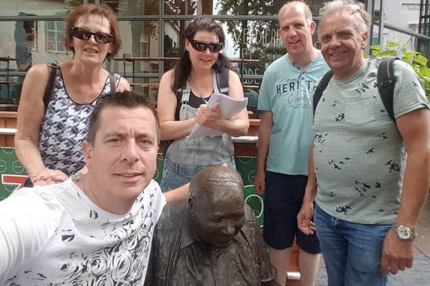 Un groupe de personnes posant à côté d’une statue en bronze représentant un gorille. 2