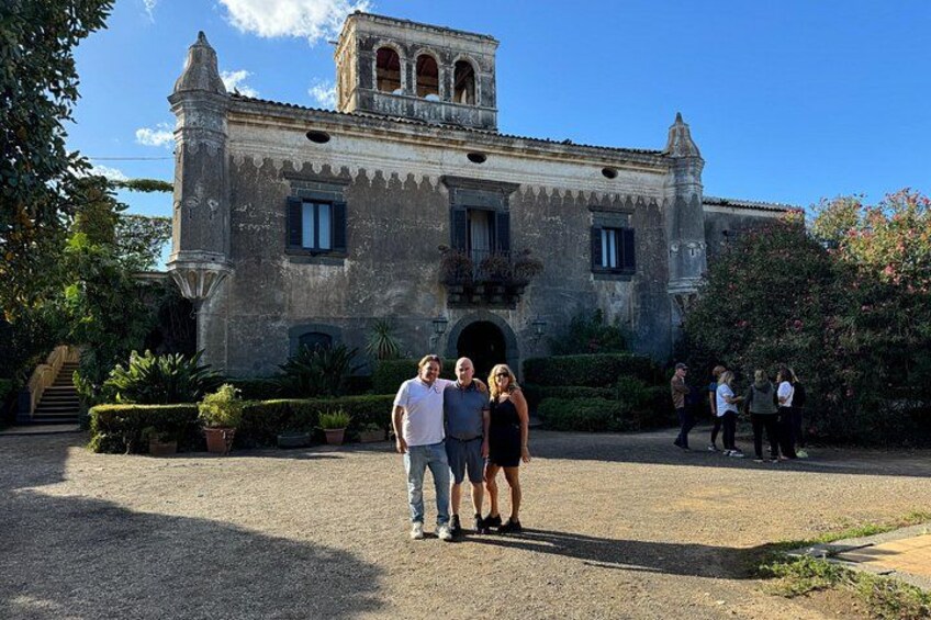Un edificio histórico con un campanario, rodeado de un jardín cuidado y un sendero de grava. 1